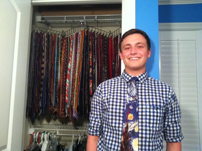 Wearing a tie, Tie Guy Michael Lepard stands in front of his closet filled with ties.