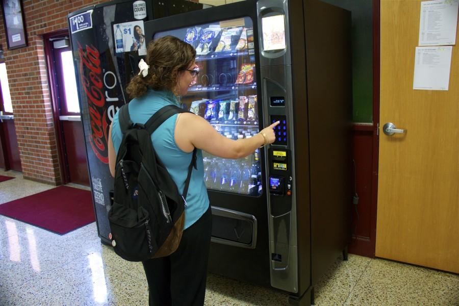 Senior Kylen Bailey purchases a snack from the vending machine. All the food from the machines will have to be healthy this year.