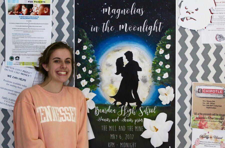 Natalie Campbell stands next to the new poster for prom on May 6.