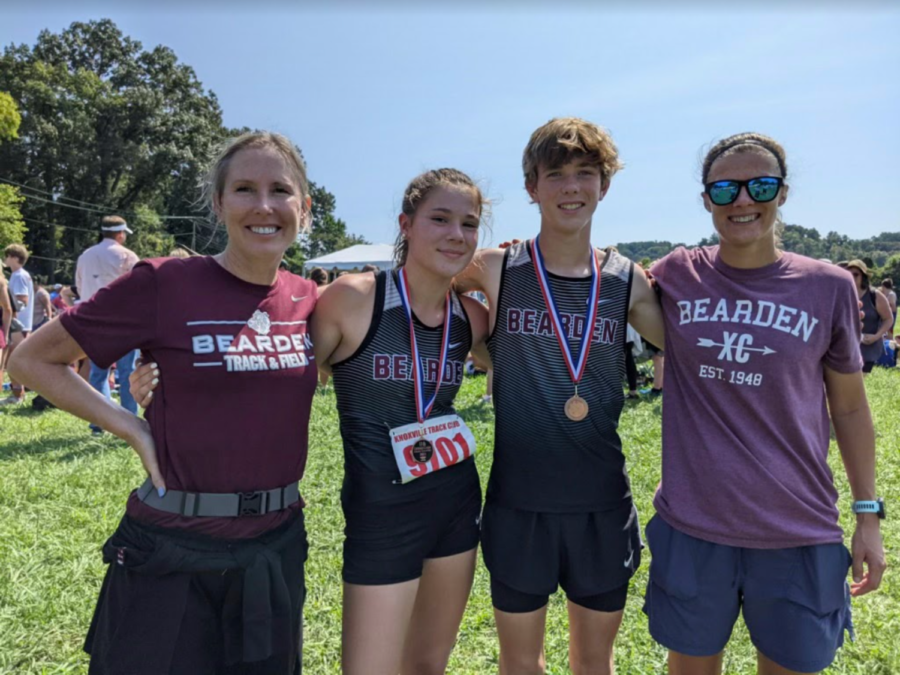 Millie Lovett and Cade Crum celebrate with assistant coach Patty Thewes (left) and head coach Ashley Schott (right) after a race last year.