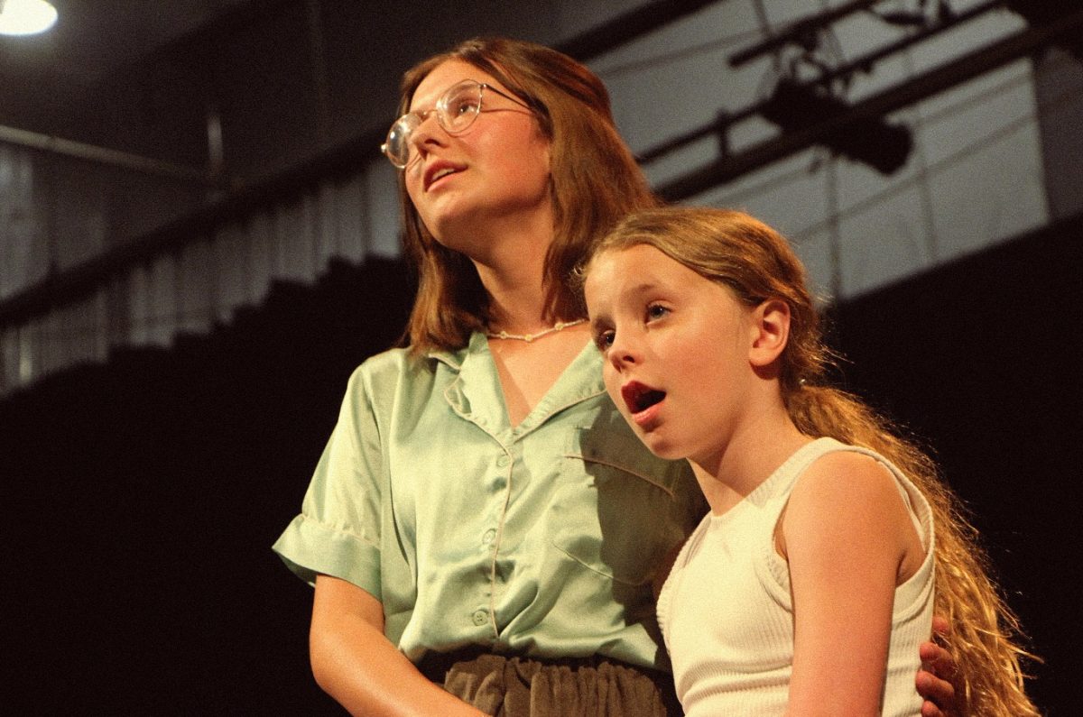 Senior Annabella Brady rehearses with Audrey McGuire, one of many elementary school students in the cast of The Music Man.