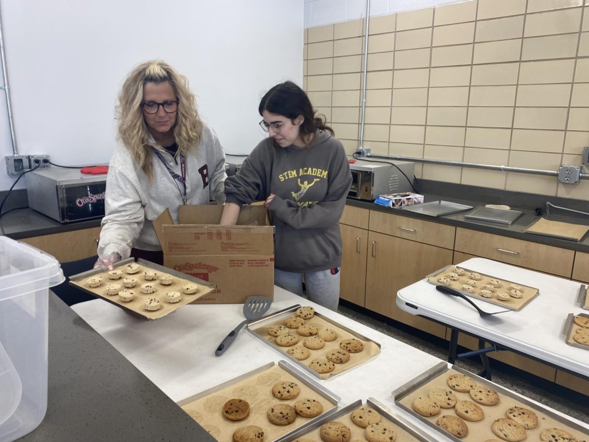 Senior+Zoe+Blakeman+and+Mrs.+Tricia+Leslie+get+cookies+ready+to+sell+to+students.