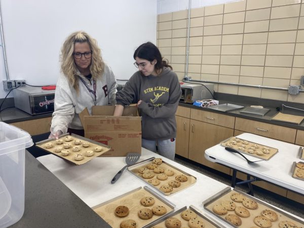 Senior Zoe Blakeman and Mrs. Tricia Leslie get cookies ready to sell to students.