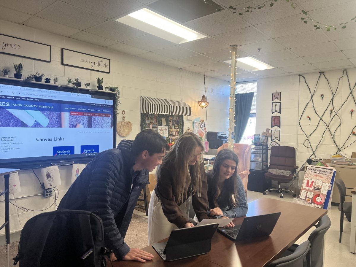 Thatcher Ella, Finley Wright, and Kendall Coe (left to right) prepare for this week's DECA competition.