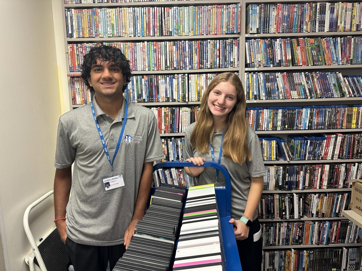 Julia Fawaz (right) volunteered with other high school students at East Tennessee Children's Hospital this summer. Her work included helping children get movies from the hospital's library.
