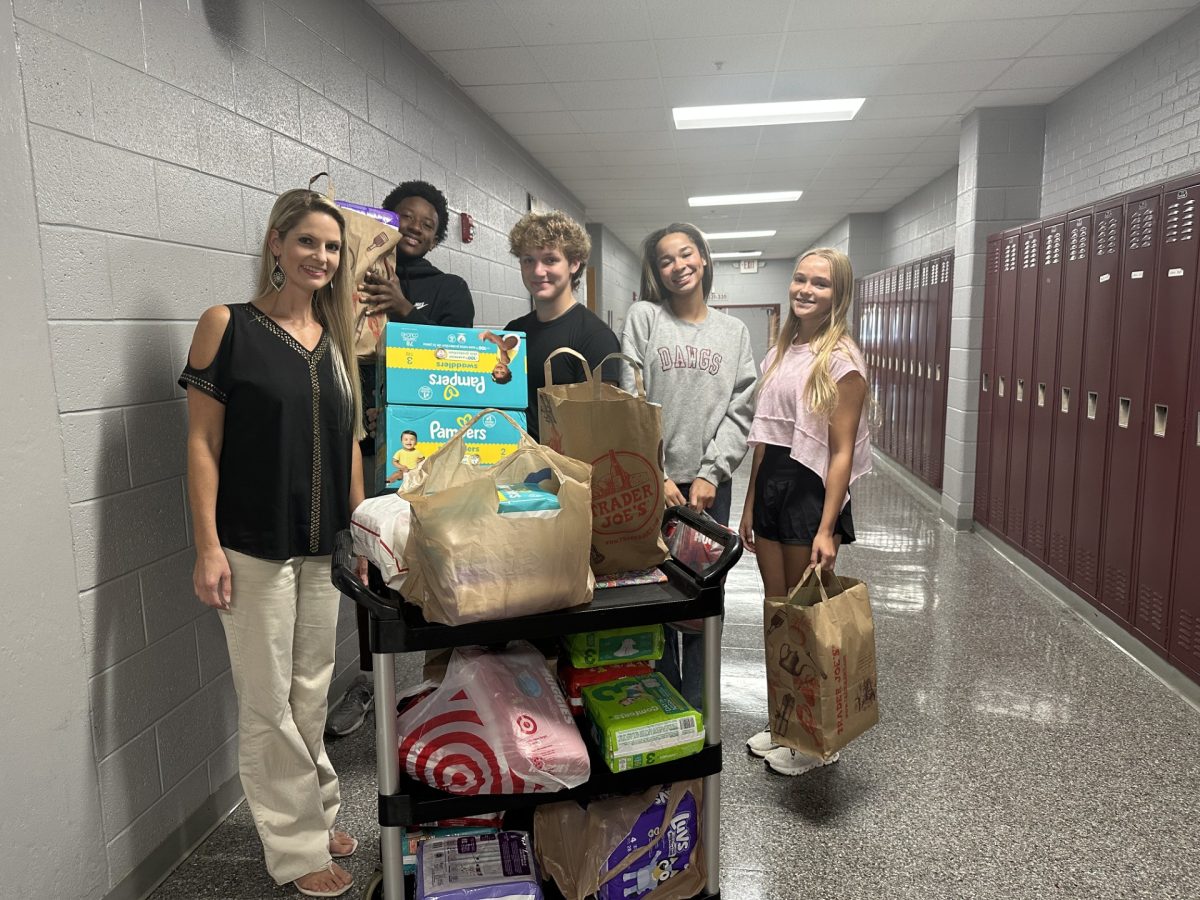 Club sponsor Mrs. Lauren Sanderson and several Bearden students load donated diapers they collected for the "Fill the Warehouse" competition.